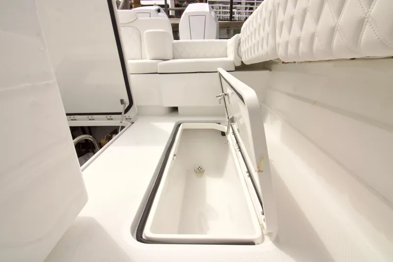 Slide: The Image of 2026 HCB 42 Lujo boat interior with open storage compartment and white seating. - 37