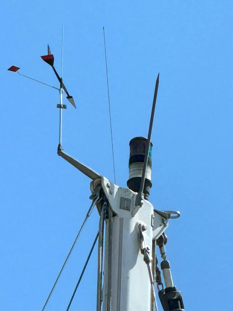 Slide: The Image of Mast top of 1975 Westsail 32 sailboat with wind vane against clear blue sky. - 16