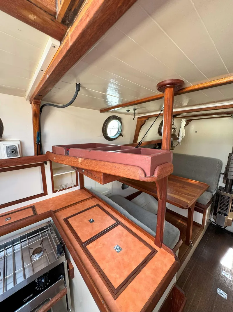 Slide: The Image of Interior of a 1975 Westsail 32 sailboat, featuring wood accents and compact living space. - 24