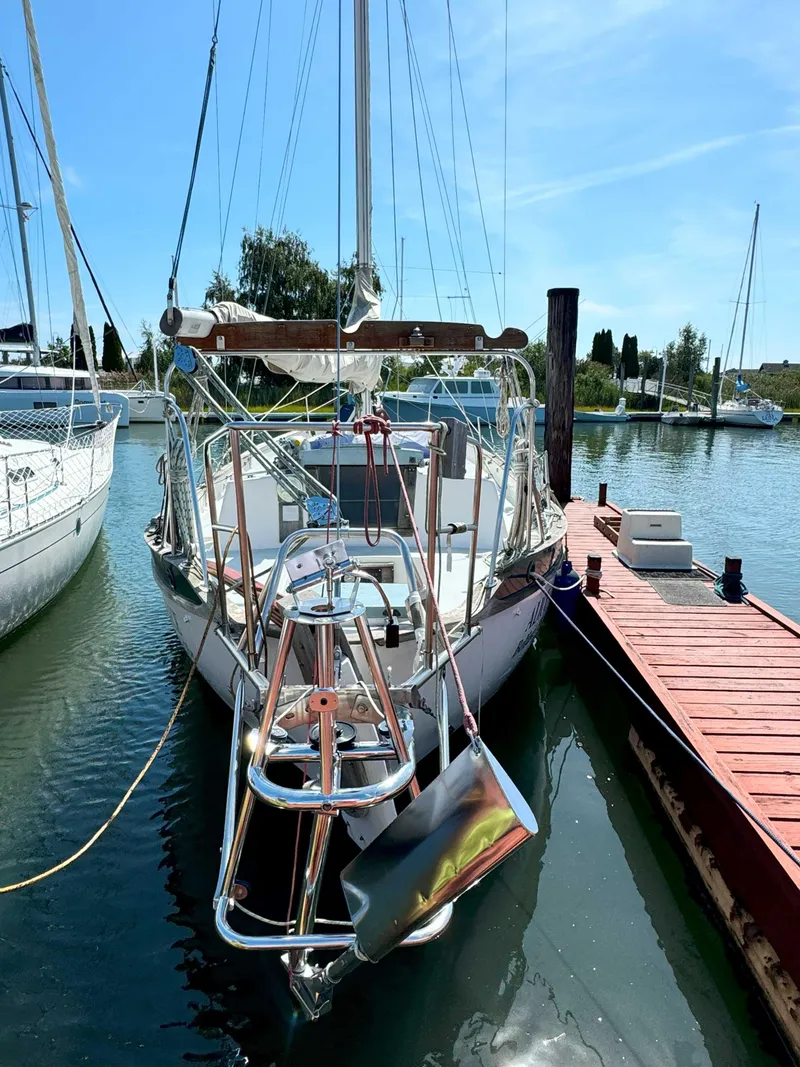 Slide: The Image of 1975 Westsail 32 sailboat docked in a marina under a clear blue sky. - 3