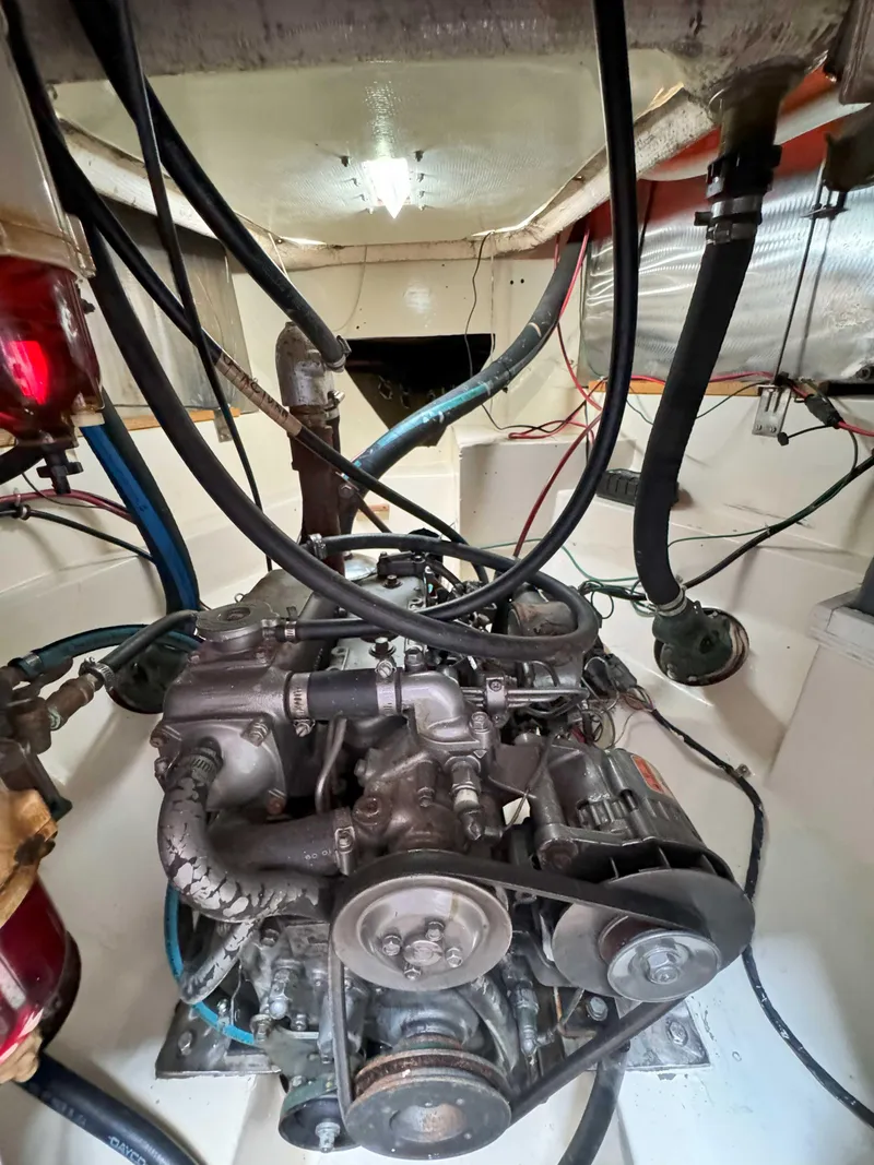Slide: The Image of Engine compartment of a 1975 Westsail 32 sailboat, showing mechanical components and wiring. - 31