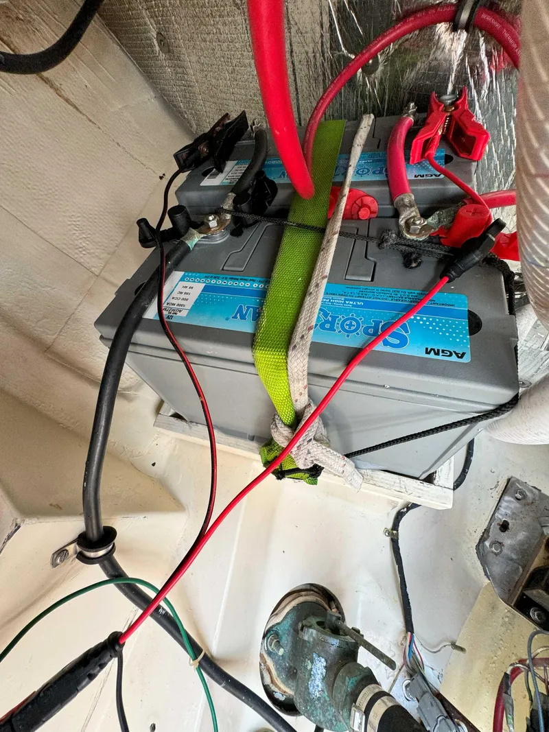 Slide: The Image of Battery setup in a 1975 Westsail 32 sailboat with connected cables and secure strapping. - 34