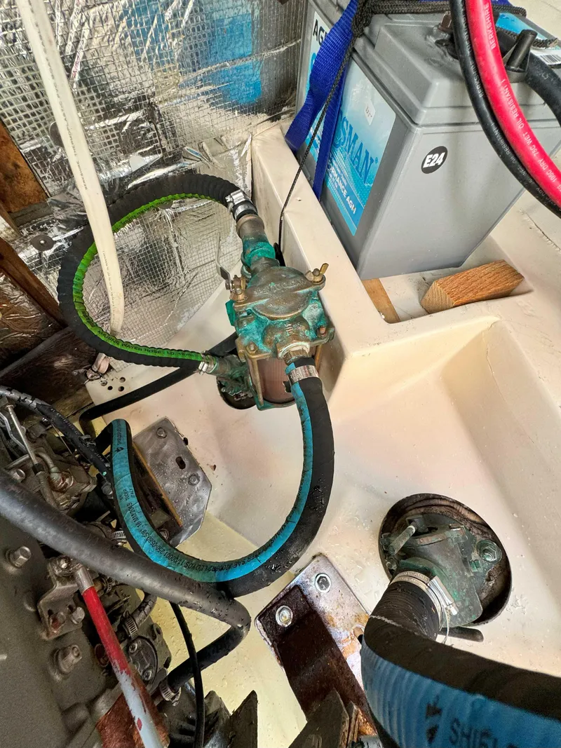 Slide: The Image of Engine compartment of a 1975 Westsail 32 sailboat with hoses and battery. - 35