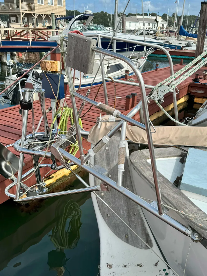 Slide: The Image of 1975 Westsail 32 sailboat docked at a marina, featuring a stainless steel wind vane. - 5