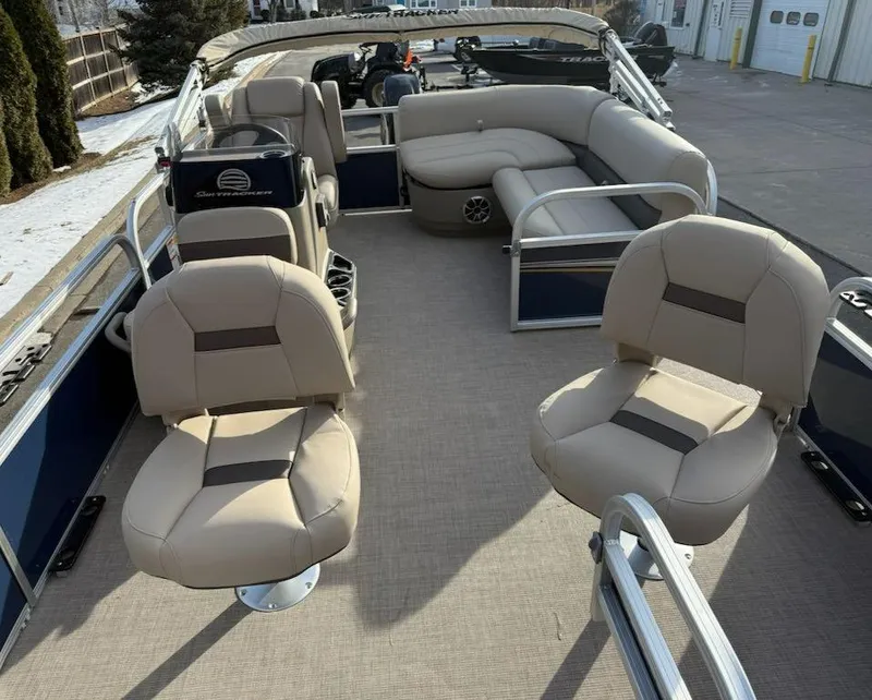Slide: The Image of 2025 Sun Tracker Bass Buggy 16 XL Select pontoon boat interior with beige seating. - 2