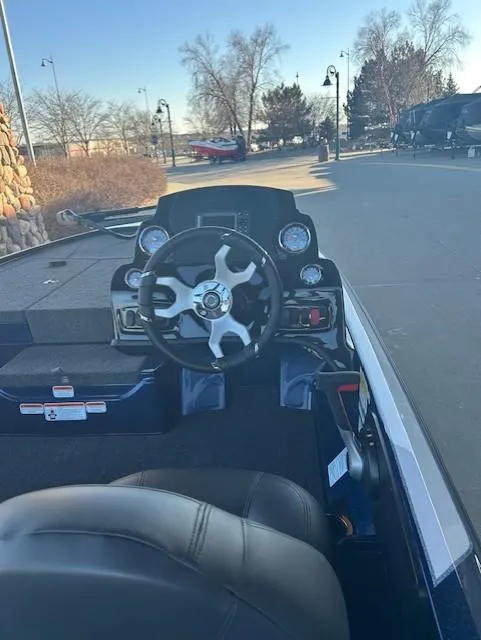 Slide: The Image of 2025 Nitro Z17 boat cockpit with steering wheel, dashboard, and seating in outdoor setting. - 2