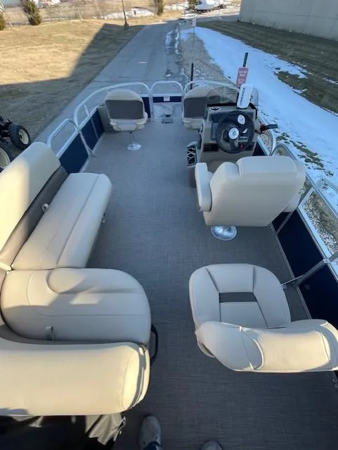 Slide: The Image of 2025 Sun Tracker Bass Buggy 18 DLX pontoon boat with beige seating and steering console. - 4