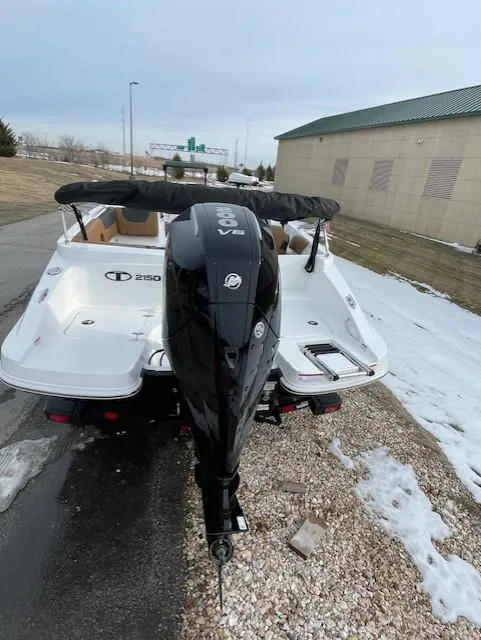 Slide: The Image of 2025 Tahoe 2150 boat with outboard motor, parked on snowy ground. - 2