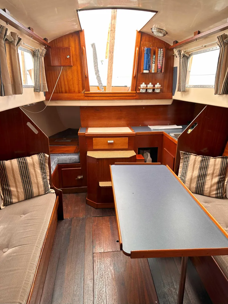 Slide: The Image of Interior of a 1969 Contest 29 sailboat with wooden furnishings and seating area. - 15