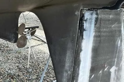 Slide: The Image of Close-up of a 1969 Contest 29 boat propeller and hull on gravel. - 4