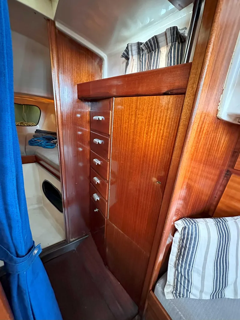 Slide: The Image of Interior of a 1969 Contest 29 sailboat with wooden cabinetry and striped curtains. - 9