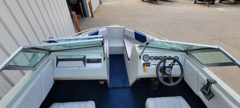 Slide: The Image of 1986 Four Winns 160 Freedom boat interior with steering wheel and seating. - 13