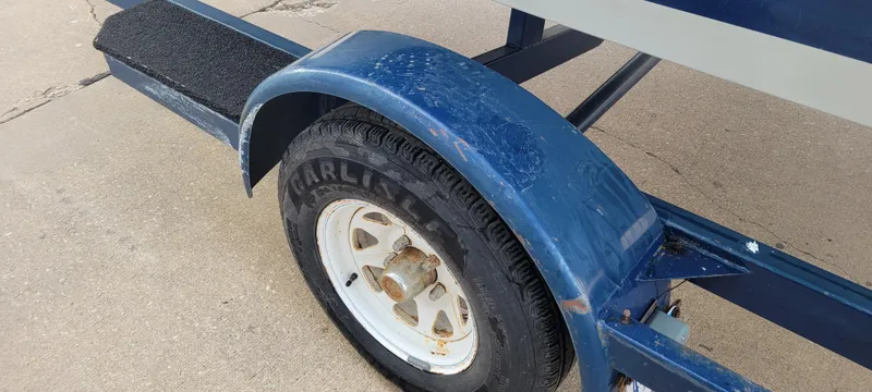 Slide: The Image of 1986 Four Winns 160 Freedom trailer wheel and fender on concrete surface. - 15