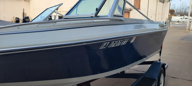 Slide: The Image of 1986 Four Winns 160 Freedom boat on trailer, blue and white exterior. - 3
