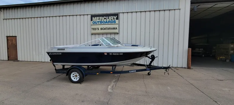 Slide: The Image of 1986 Four Winns 160 Freedom boat on trailer outside Mercury Outboards building. - 4