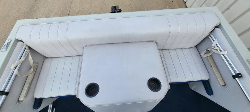 Slide: The Image of 1986 Four Winns 160 Freedom boat interior with white seating and cup holders. - 7
