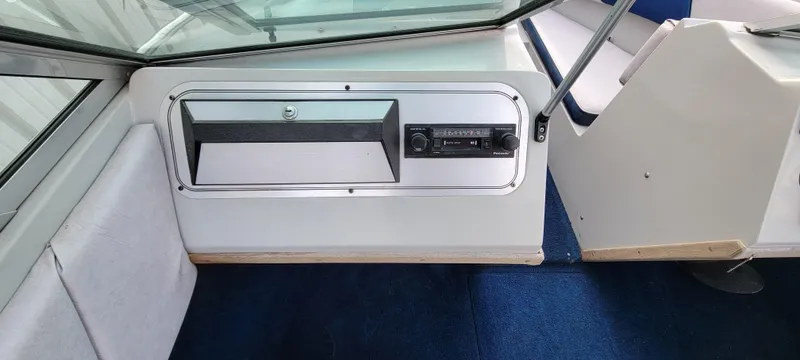 Slide: The Image of Interior of 1986 Four Winns 160 Freedom boat with blue carpet and dashboard controls. - 8