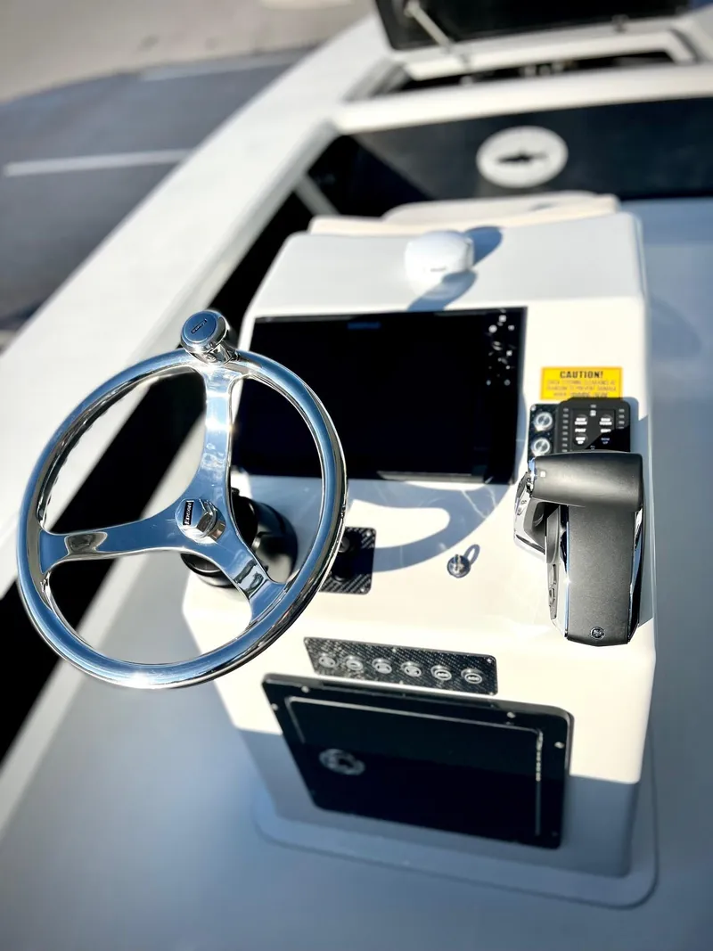 Slide: The Image of 2025 Chittum Skiffs 21R boat console with steering wheel and controls. - 3
