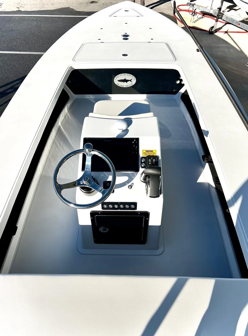 Slide: The Image of 2025 Chittum Skiffs 21R boat interior with steering wheel and control panel. - 7
