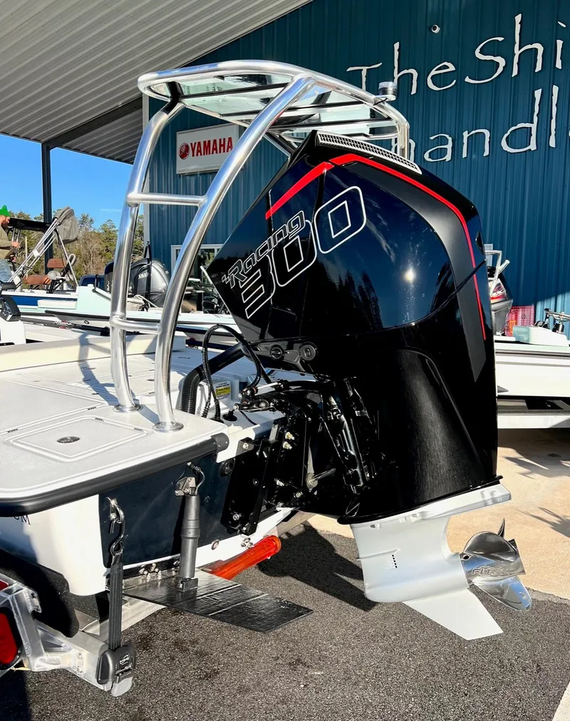 Slide: The Image of 2025 Chittum Skiffs 21R with powerful outboard motor at dealership. - 9