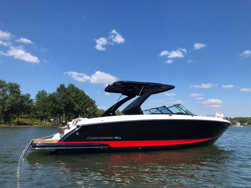 Slide: The Image of 2019 Chaparral 297 SSX boat on a lake under a clear blue sky. - 1