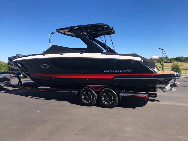 Slide: The Image of 2019 Chaparral 297 SSX boat on trailer, black with red accents, parked outdoors. - 3