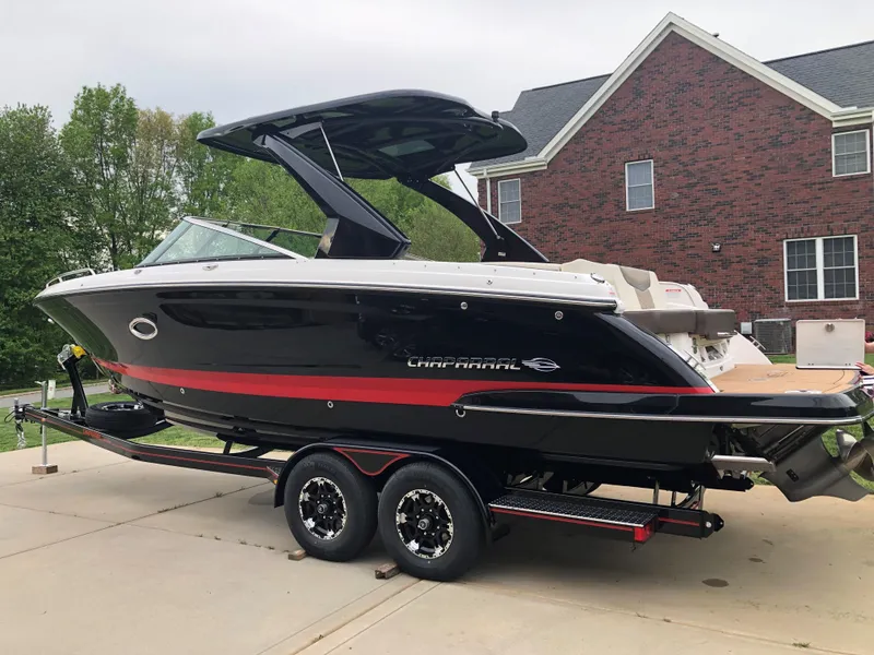 Slide: The Image of 2019 Chaparral 297 SSX boat on trailer, parked in driveway near brick house. - 5