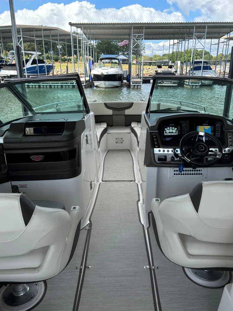Slide: The Image of 2019 Chaparral 297 SSX boat interior with dual helm seats at a marina. - 6