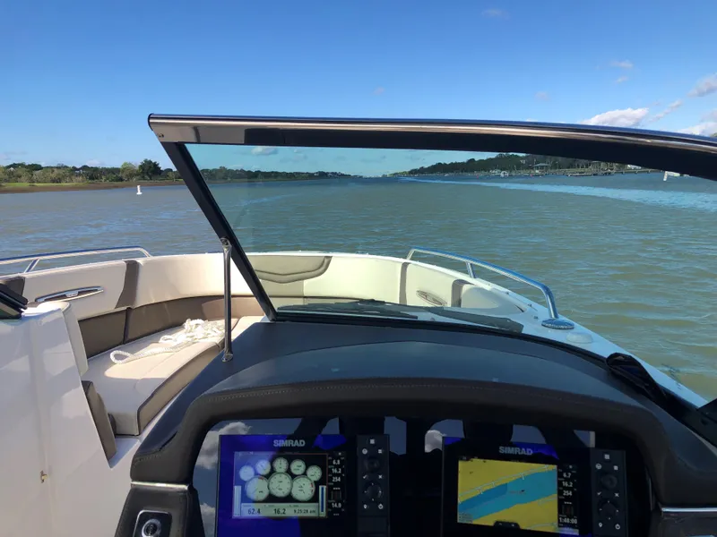 Slide: The Image of 2019 Chaparral 297 SSX boat dashboard with navigation screens on a calm river. - 7