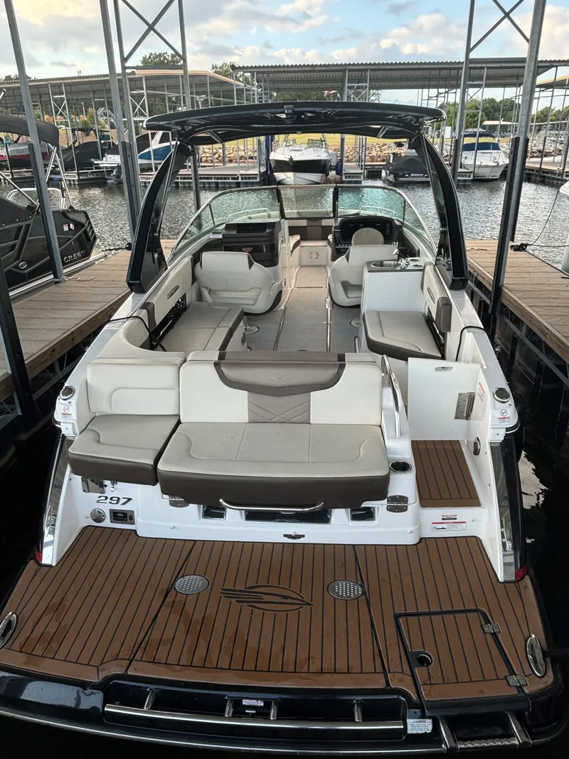 Slide: The Image of 2019 Chaparral 297 SSX boat with spacious seating and elegant design at a marina. - 8