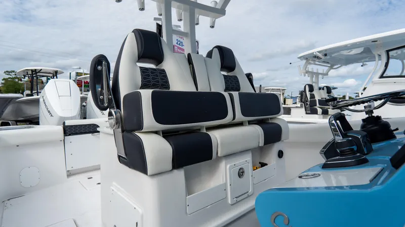 Slide: The Image of 2025 Tidewater 320 CC Adventure boat interior with black and white seating. - 16