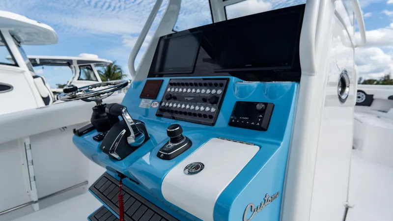 Slide: The Image of 2025 Tidewater 320 CC Adventure boat console with modern controls and display. - 19