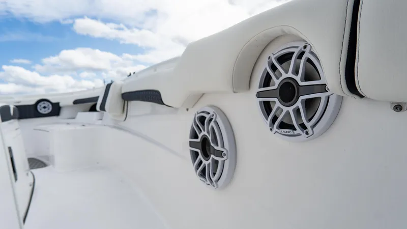 Slide: The Image of 2025 Tidewater 320 CC Adventure boat speakers and seating detail under blue sky. - 26