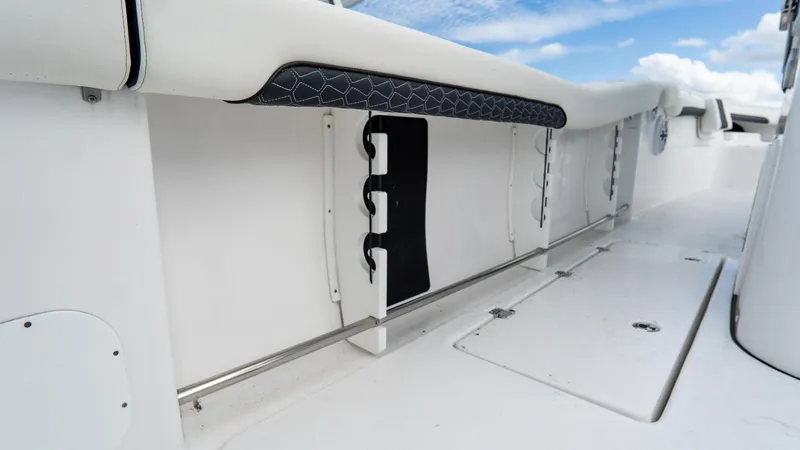 Slide: The Image of 2025 Tidewater 320 CC Adventure boat interior with rod holders and sleek white design. - 27