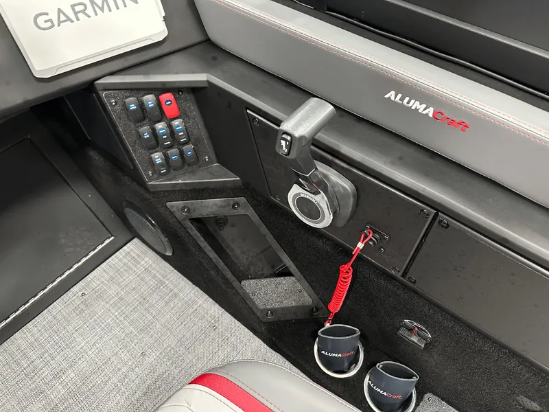 Slide: The Image of 2025 Alumacraft Trophy 185X Sport boat interior with seating and controls, displayed at a marine store. - 11