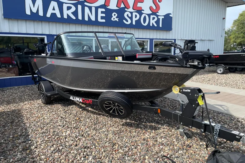 Slide: The Image of 2025 Alumacraft Trophy 185X Sport boat displayed indoors on a trailer. - 22