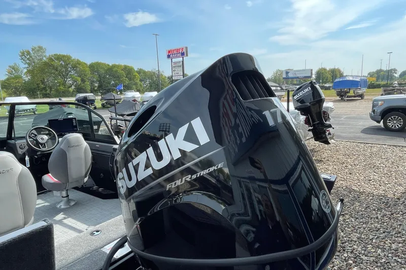 Slide: The Image of 2025 Alumacraft Trophy 185X Sport boat displayed indoors with American flag backdrop. - 25