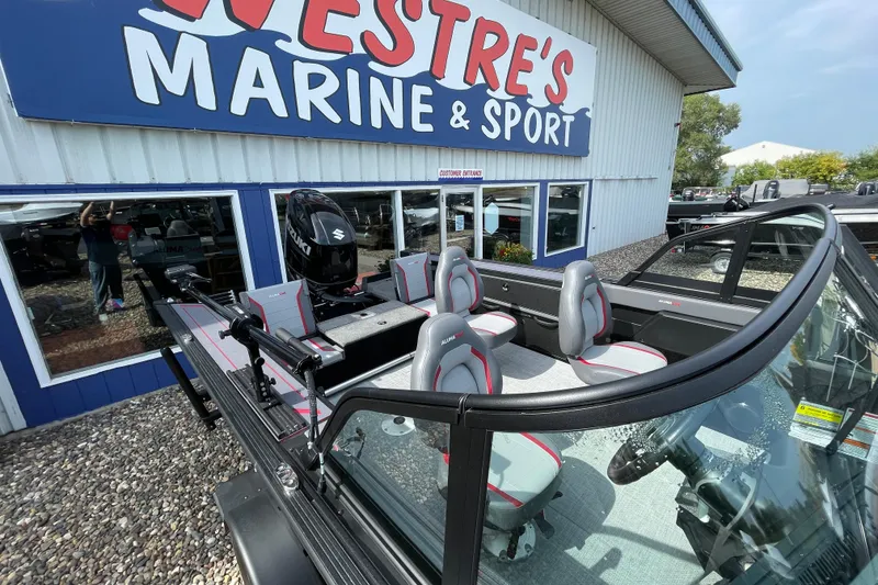 Slide: The Image of 2025 Alumacraft Trophy 185X Sport boat interior with open storage compartments and carpeted deck. - 29