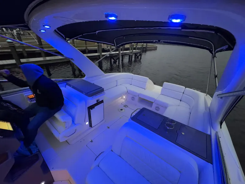 Slide: The Image of 2005 Regal 3350 Sport Cruiser interior with blue LED lighting at a dock. - 12
