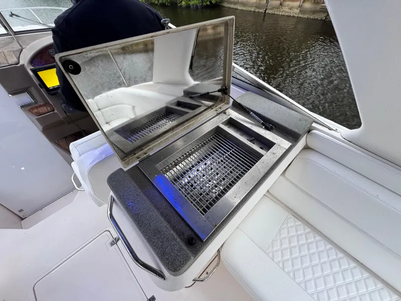 Slide: The Image of 2005 Regal 3350 Sport Cruiser with onboard grill, featuring sleek seating and water view. - 19