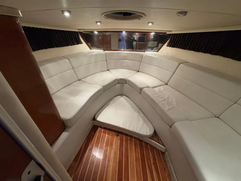 Slide: The Image of 2005 Regal 3350 Sport Cruiser interior with white seating and wooden flooring. - 21