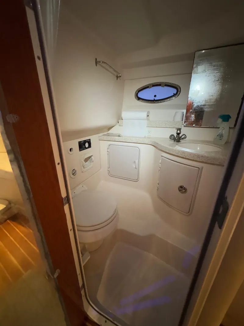 Slide: The Image of 2005 Regal 3350 Sport Cruiser bathroom interior with sink, toilet, and porthole window. - 22