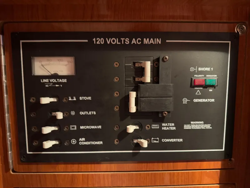 Slide: The Image of 2005 Regal 3350 Sport Cruiser electrical panel with 120 volts AC main controls. - 25