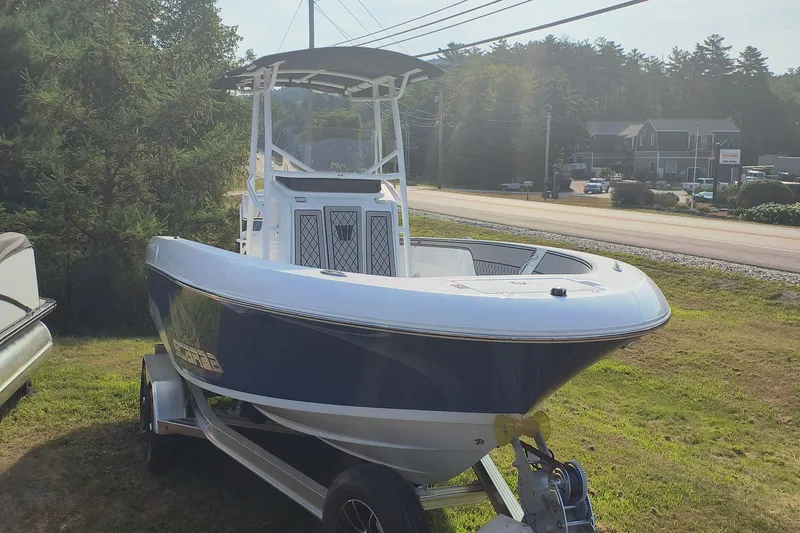 The Image of 2025 Wellcraft 202 Fisherman boat on trailer, parked on grassy area near road. - 0