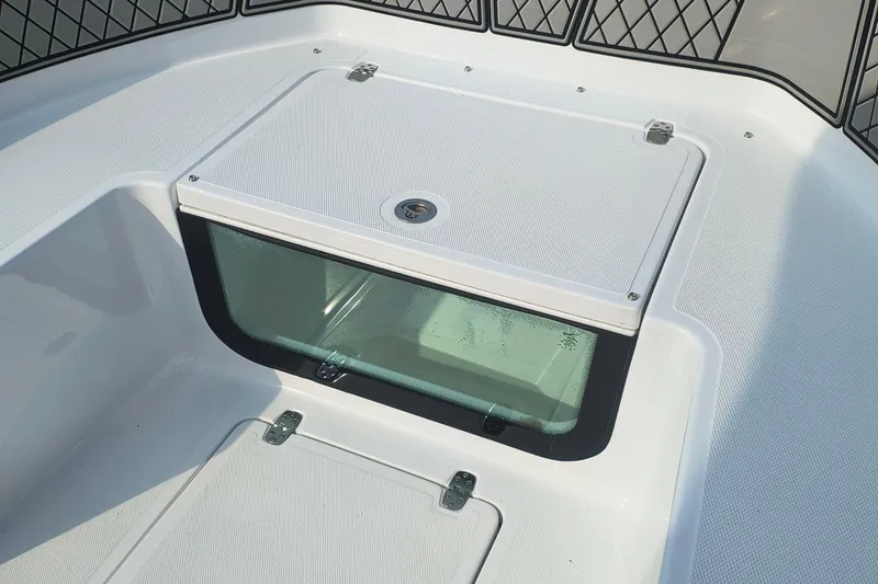 Slide: The Image of 2025 Wellcraft 202 Fisherman boat deck with storage compartment and safety netting. - 15