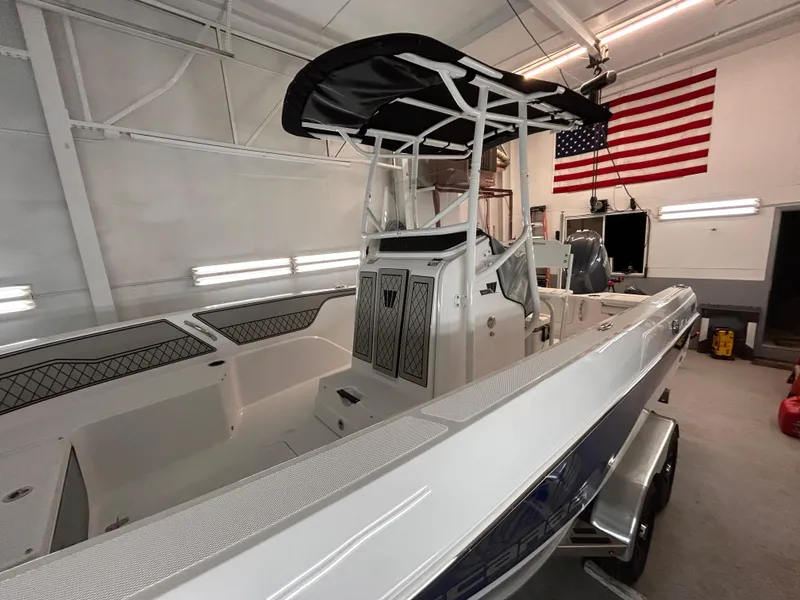 Slide: The Image of 2025 Wellcraft 202 Fisherman boat in garage, American flag in background. - 6