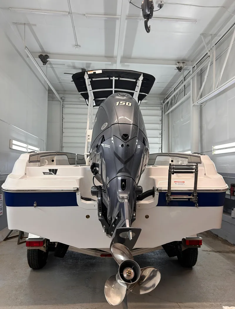 Slide: The Image of 2025 Wellcraft 202 Fisherman boat with powerful outboard motor in a garage setting. - 9