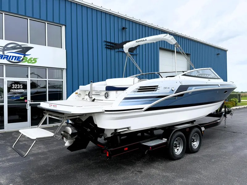 Slide: The Image of 2025 Formula 270 Bowrider boat on trailer outside blue building. - 10