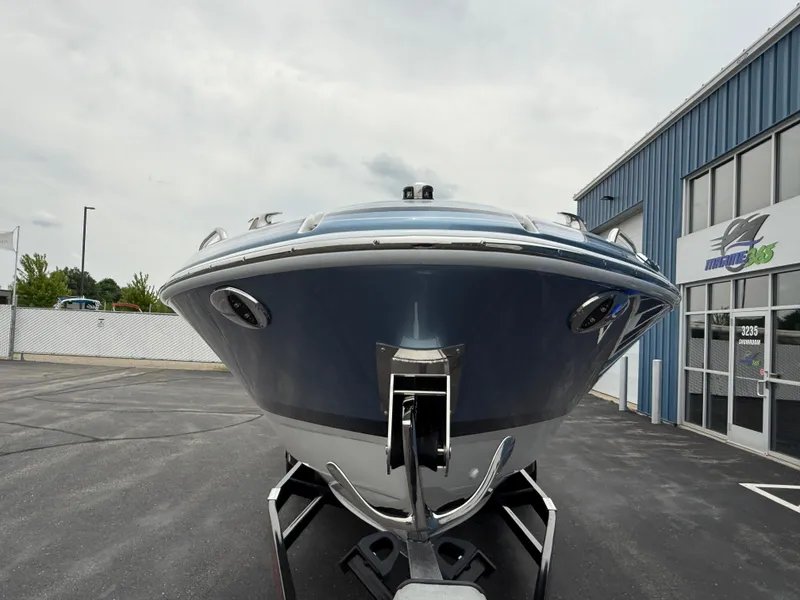 Slide: The Image of 2025 Formula 270 Bowrider boat on trailer, parked outside a blue building. - 4