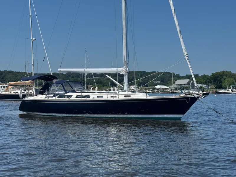 The Image of 1987 Sabre 42 sailboat anchored on calm water under clear blue sky. - 0